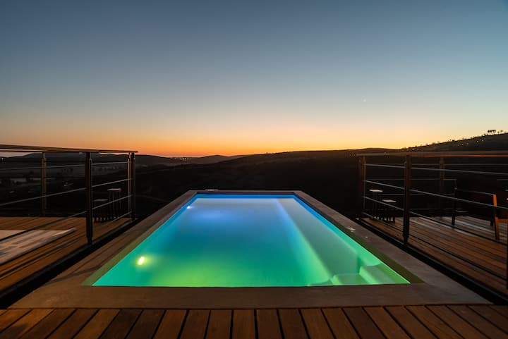 Blue hour — the lit pool against the last light over the hills