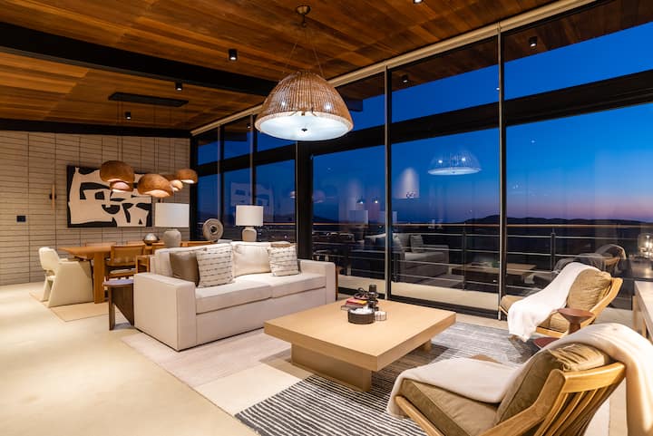 The great room, glass on every side, opening to the view