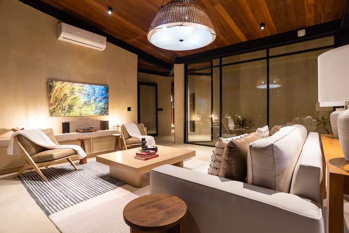 The living room, lamplit and unhurried