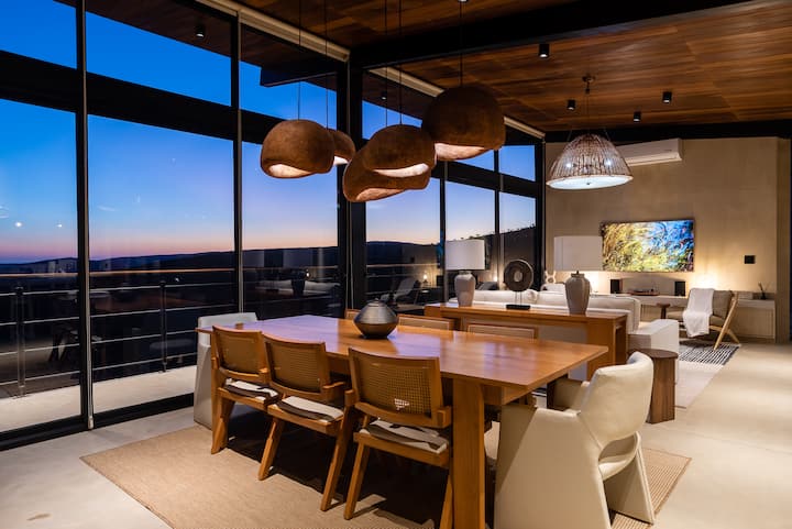 The dining table set against the glass and the view