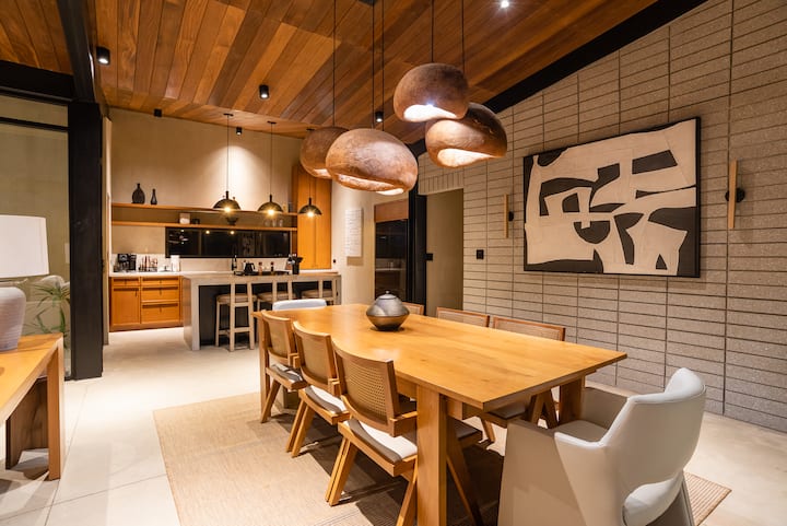 Dining and kitchen open to one another under the timber ceiling