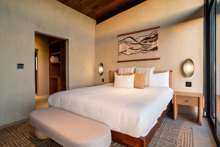A bedroom with art, texture and morning light