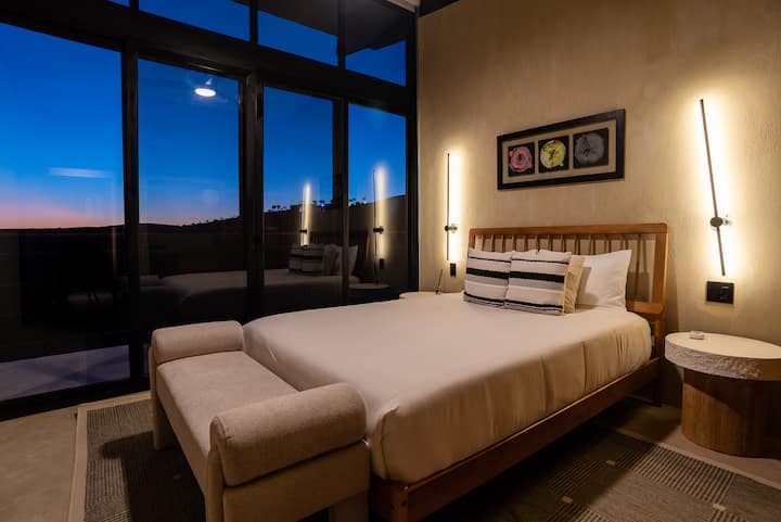 Two beds beneath sculptural wall lamps