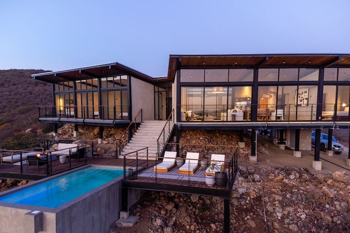 The villa lit from within at nightfall