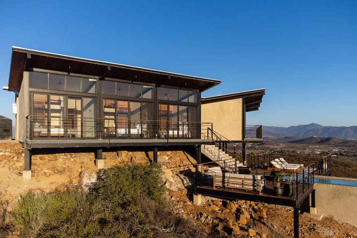 Casa Finch from the hillside — a glass pavilion on the ridge