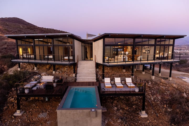 Twilight — the villa and pool glowing above the valley
